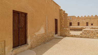 Un patio con paredes de piedra y puertas de madera.