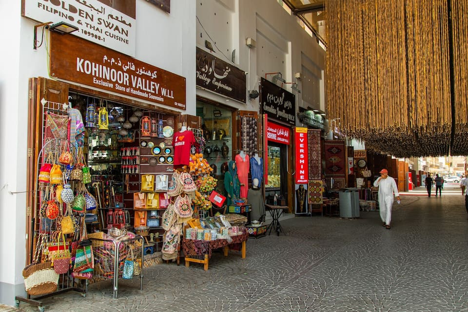Un carrer de mercat animat amb botigues que venen articles d'artesania, joieria i records.