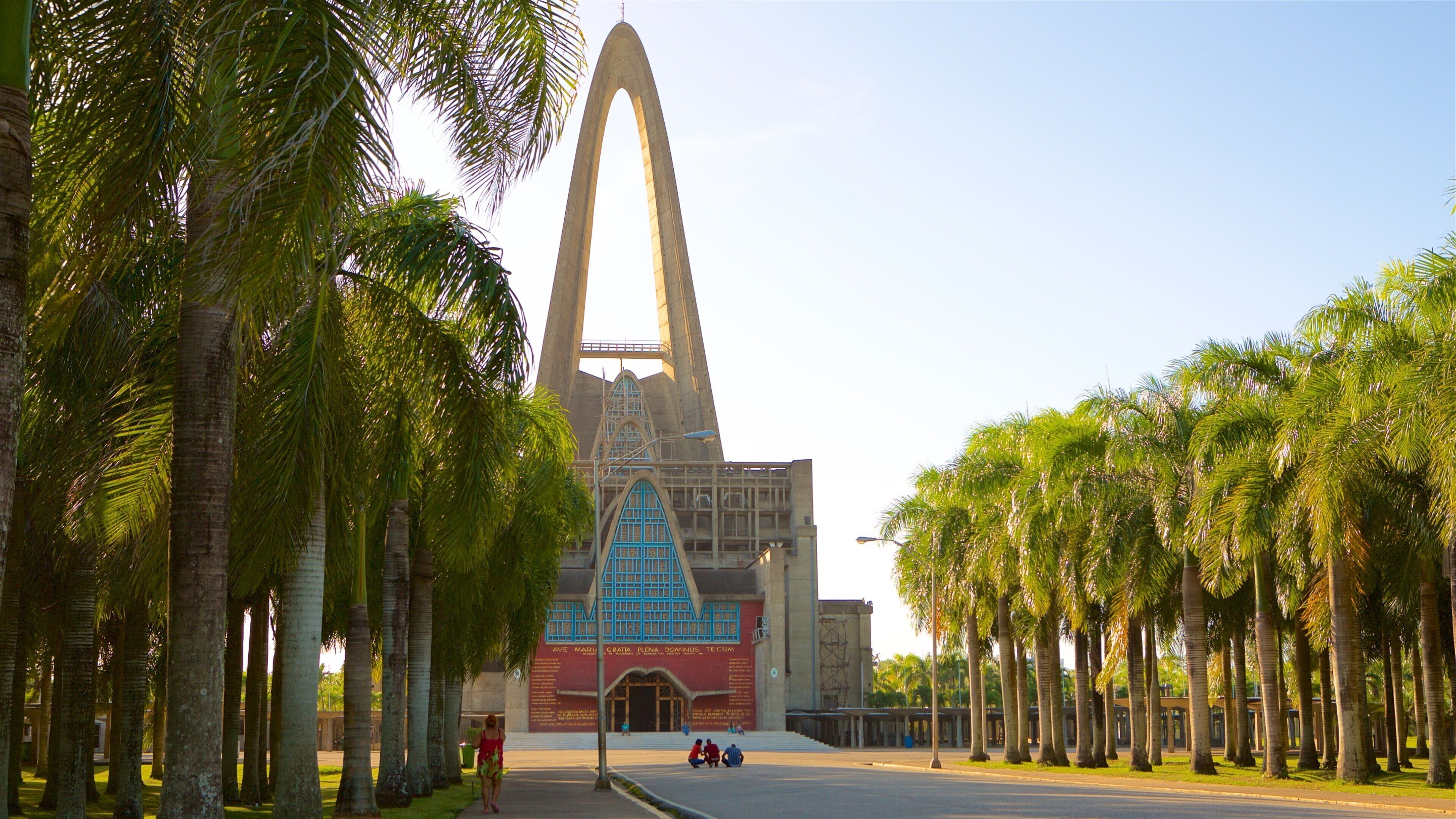 Catedral de La Altagracia mostrando arquitectura moderna y una puesta de sol y también un pequeño grupo de personas