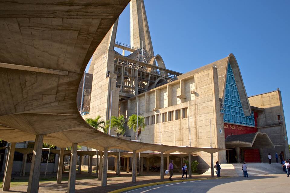 Ein großes, modernes Gebäude mit einzigartigem architektonischen Design, das einen markanten Uhrturm und einen blau gerahmten Eingang aufweist.