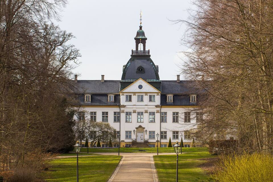 Een groot, historisch gebouw met een opvallende toren en een symmetrische gevel.