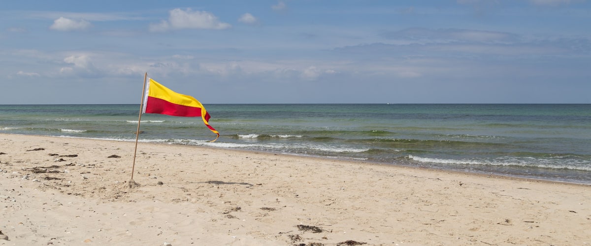 Red and yellow swimming area flag at Tisvilde beach in Denmark.; Shutterstock ID 441099616