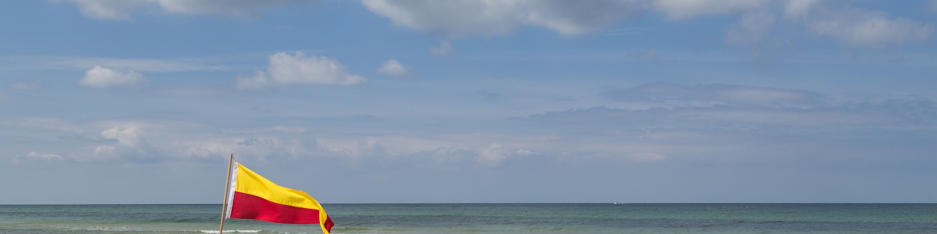 Red and yellow swimming area flag at Tisvilde beach in Denmark.; Shutterstock ID 441099616