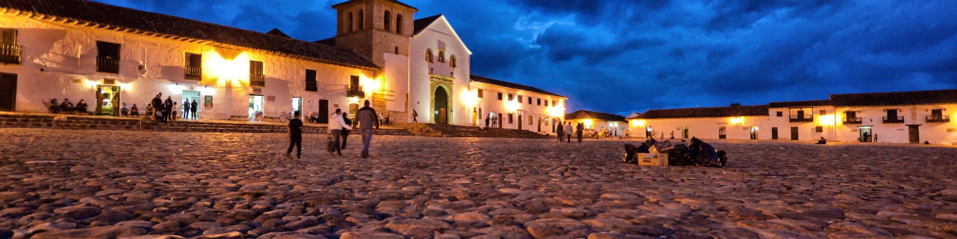 Low wide-angle photo of Villa de Leyva Plaza taken at dusk toward the church