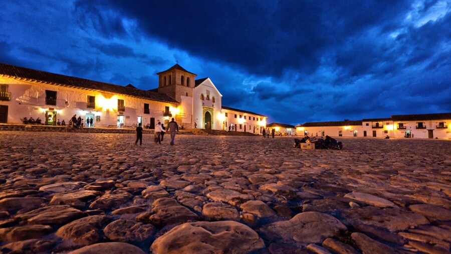 Low wide-angle photo of Villa de Leyva Plaza taken at dusk toward the church