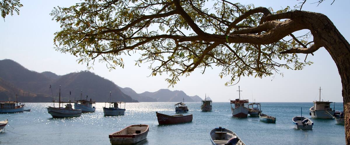 Playa Taganga mostrando una bahía o un puerto, embarcaciones y una playa de arena