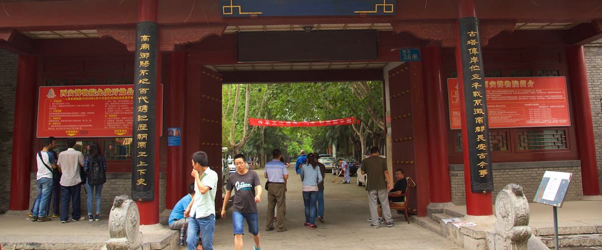 Giant Wild Goose Pagoda which includes a temple or place of worship and signage as well as a small group of people
