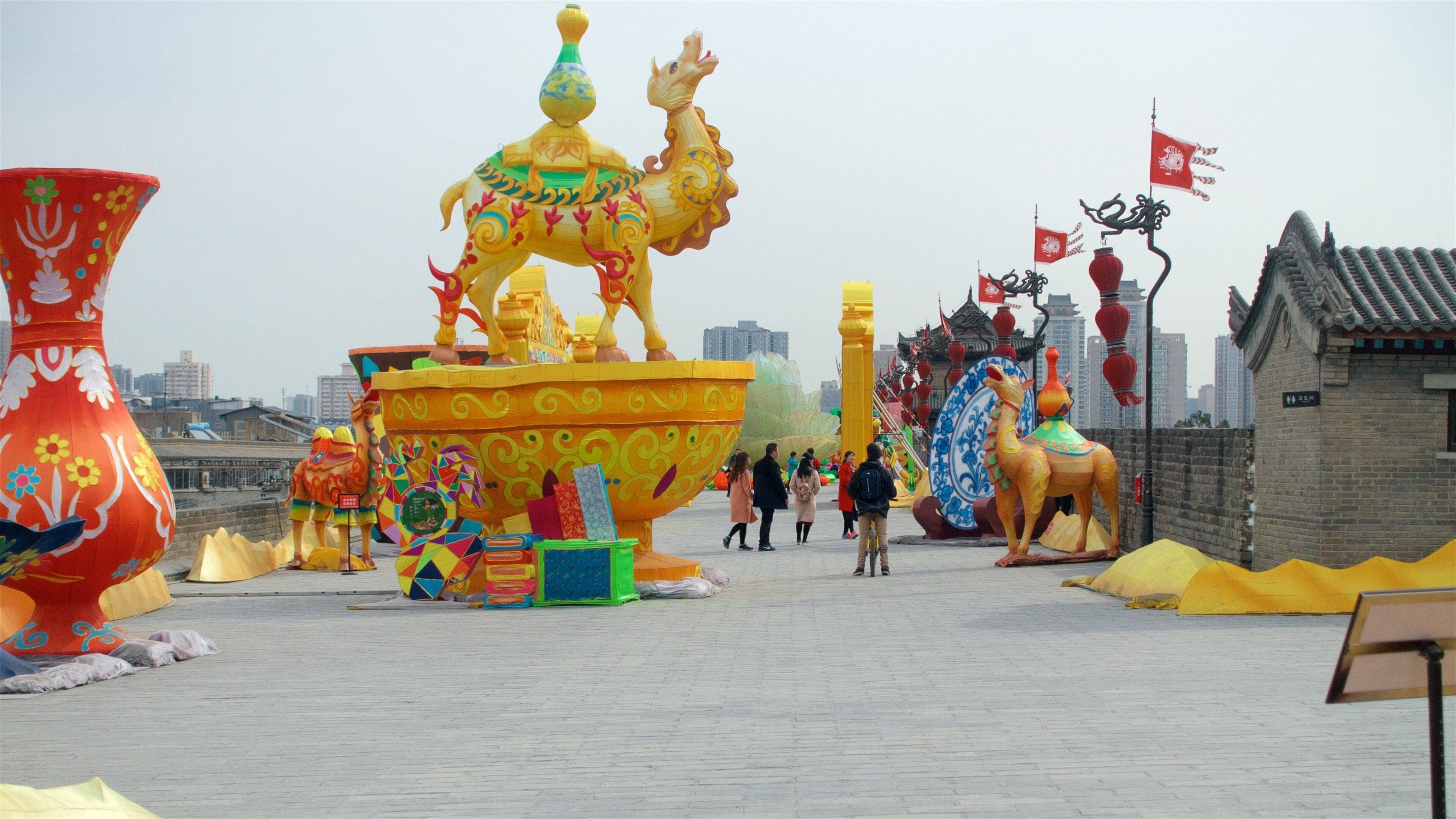 A large, colorful dragon sculpture in a public square.