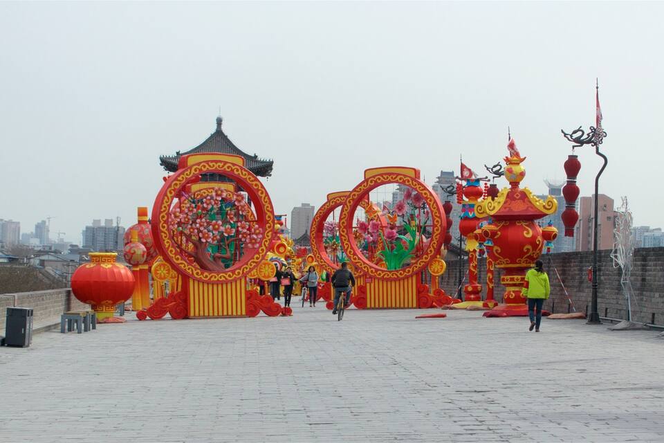 A festive outdoor area with traditional Chinese architecture, including ornate gates and lanterns.