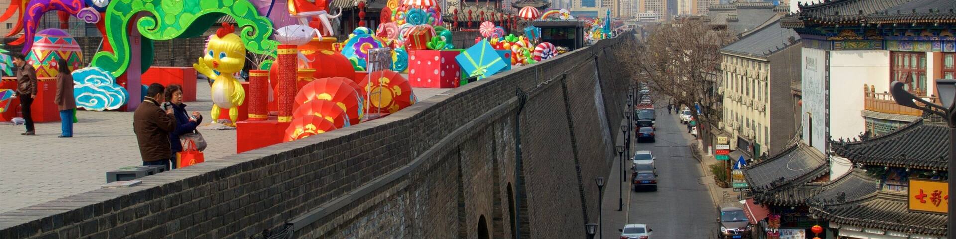Una calle bordeada por edificios de arquitectura tradicional y una exhibición vibrante de faroles y decoraciones coloridas.