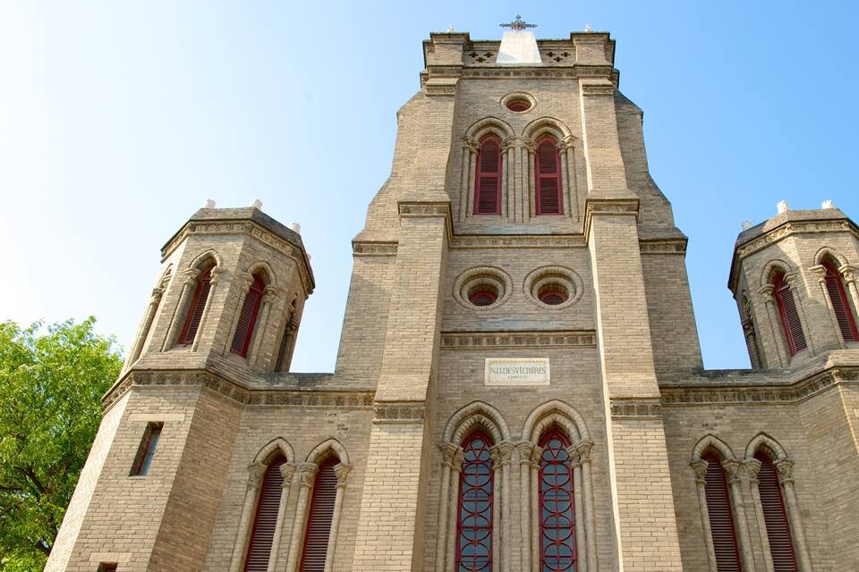A historic church with a tall tower, arched windows, and a plaque reading "N.D. Des Victoriens."
