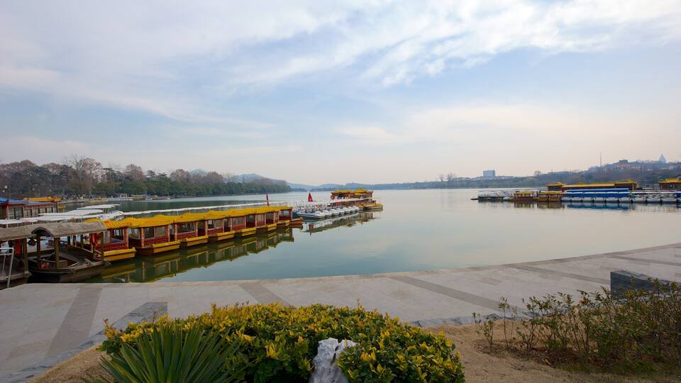 A calm river with yellow and blue boats docked at the pier.