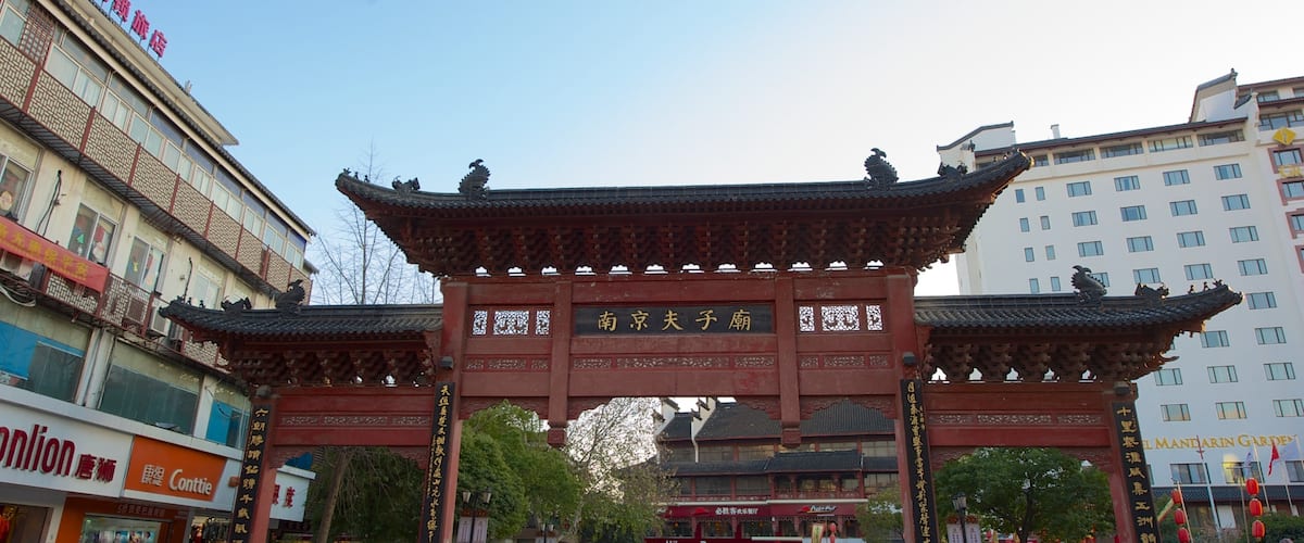 A traditional Chinese gate with intricate carvings and a sign in Chinese characters.