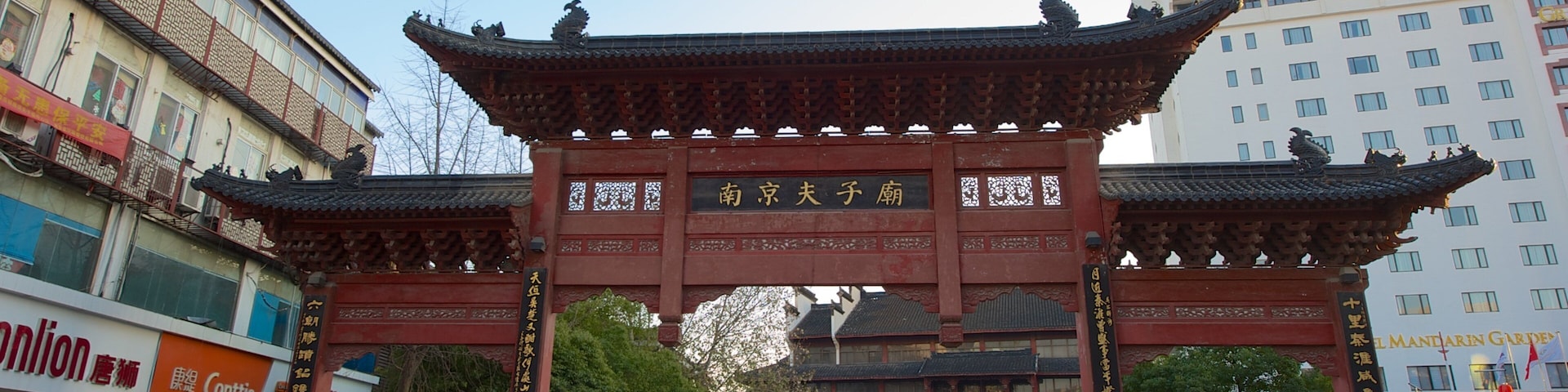A traditional Chinese gate with intricate carvings and a sign in Chinese characters.