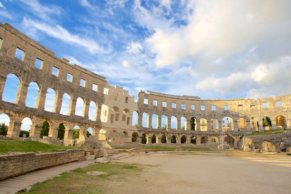 Un anfiteatro antiguo con múltiples arcos y ruinas.