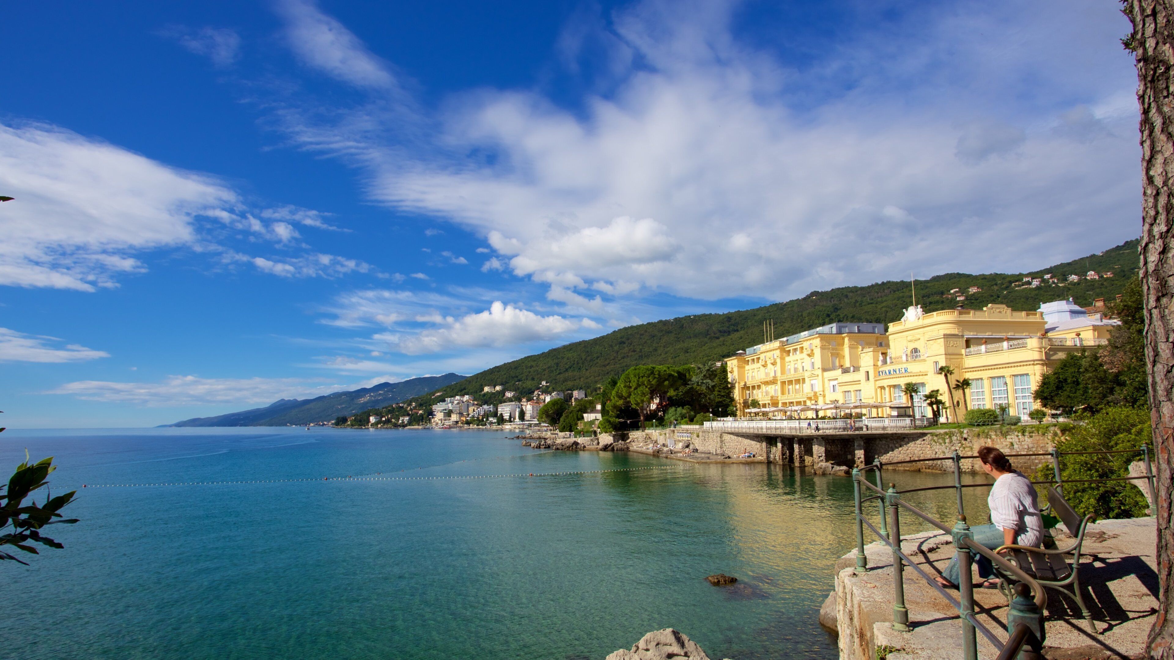 A coastal town with clear blue waters, a pier, and a prominent yellow building with 'YARNER' on it.