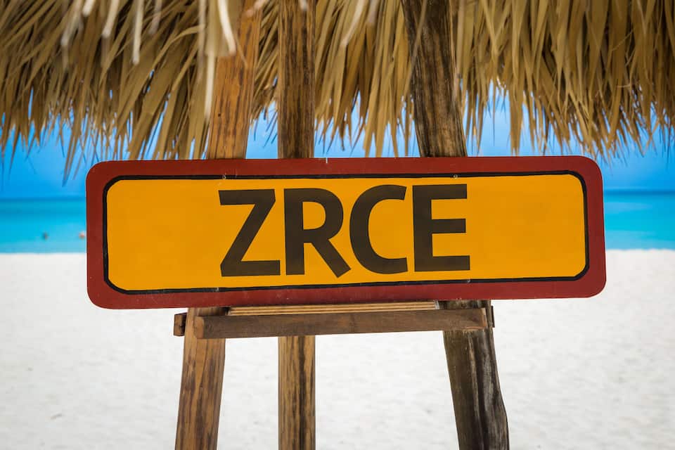 Un letrero de playa con la palabra "ZRCE" sobre un soporte de madera.
