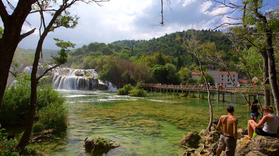 Krka National Park featuring rapids and a lake or waterhole as well as a small group of people