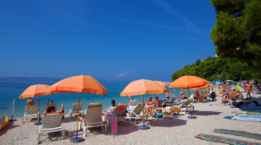 Baska Voda strand fasiliteter samt strand med småstein i tillegg til en liten gruppe med mennesker