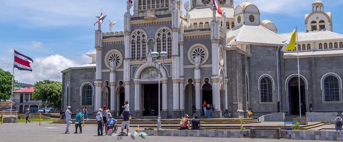 A grand historical building with domed architecture and multiple flags.