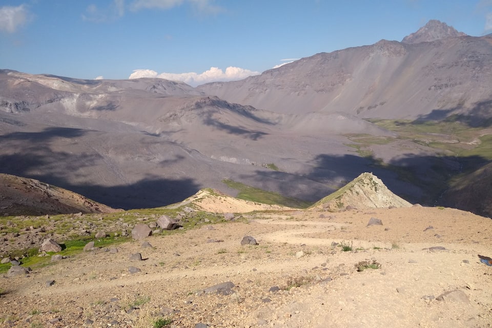 Un paisaje montañoso con terreno rocoso y vegetación escasa.
