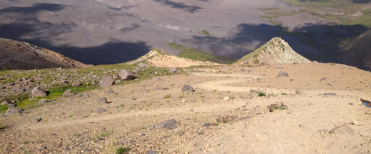 A mountainous landscape with rocky terrain and sparse vegetation.