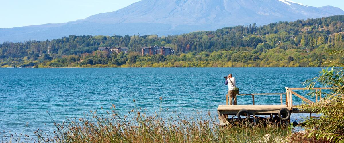 Lake Villarrica showing mountains and a lake or waterhole as well as an individual male