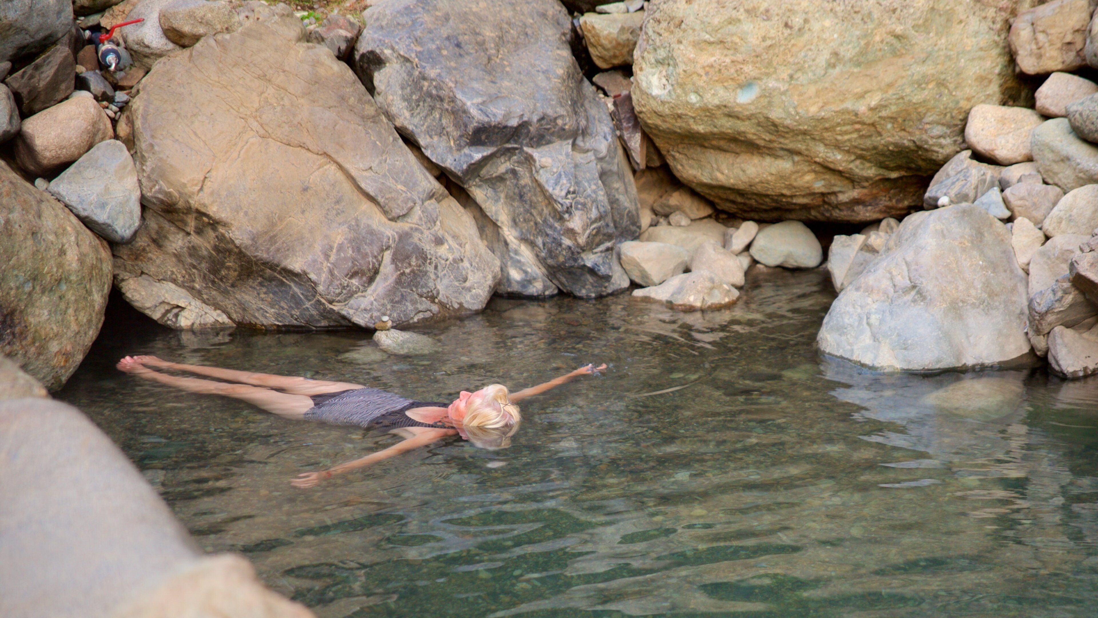 Los Pozones Hot Springs featuring a hot spring and swimming as well as an individual femail