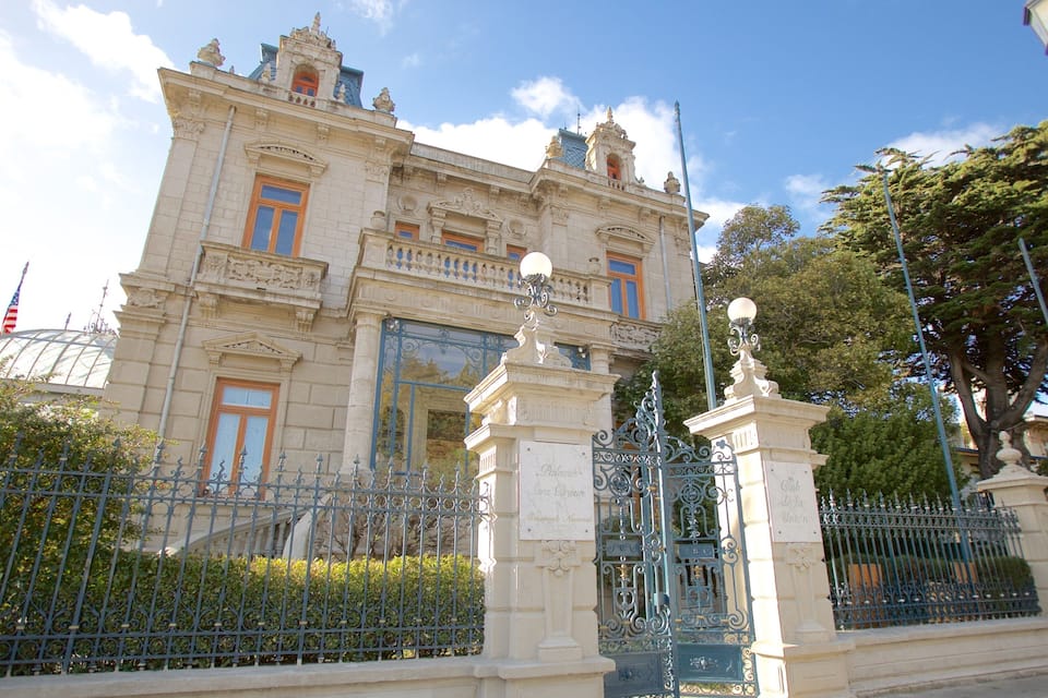 Un edificio histórico con arquitectura ornamentada, una cúpula y una estatua en su fachada.