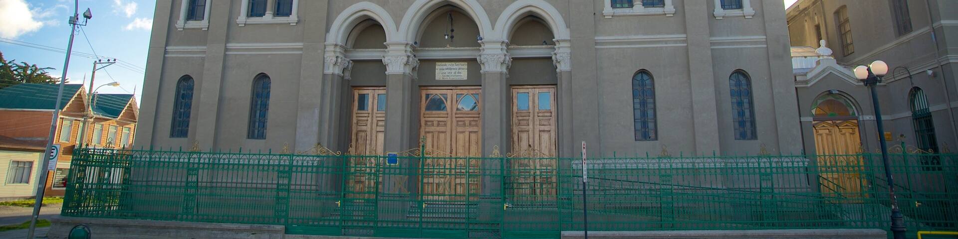 Un grand bâtiment historique doté d’une fenêtre circulaire remarquable et de portes en arc de cercle.