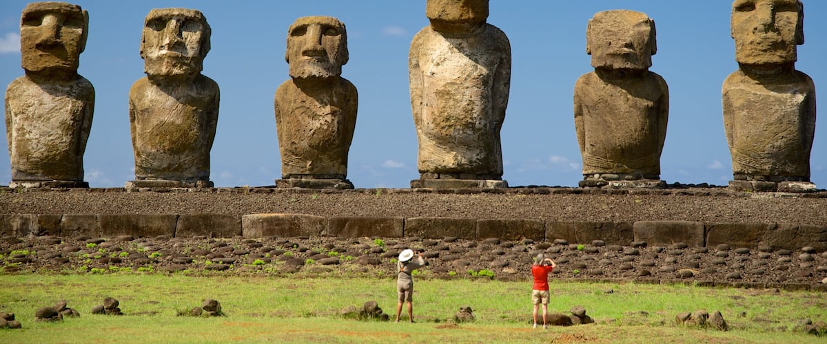 Ahu Tongariki showing a statue or sculpture and heritage elements as well as a small group of people