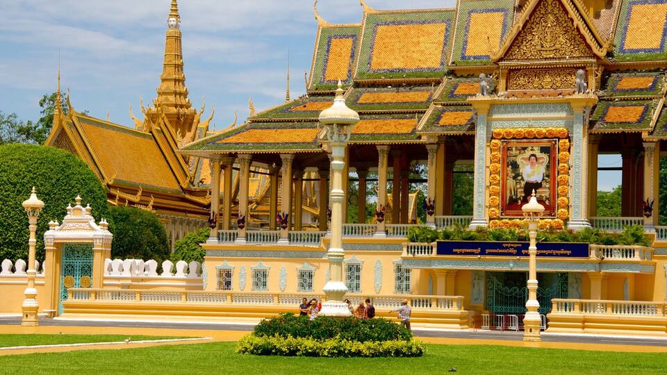 Ein prächtiger Tempel mit aufwendigen goldenen Dächern und einer großen Statue davor.