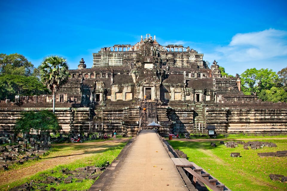 Un vaste complexe de temples anciens, avec un escalier central menant à une plateforme surélevée.
