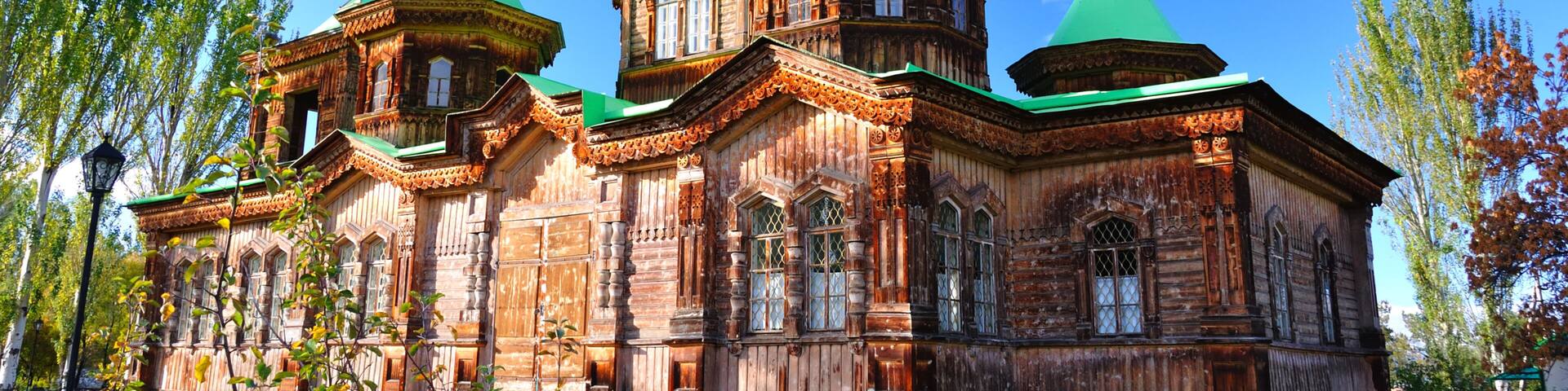 The Russian Orthodox Holy Trinity Cathedral in Karakol, Church, stands adorned with golden domes and crosses, its wooden frame contrasted the clear blue winter sky