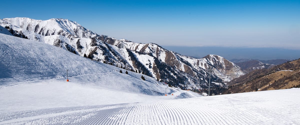 Famous Shymbulak mountain ski resort view with beautiful white and snowy ski lines, blue sky, fresh air. Wonderful picturesque resort for holidays, travelling and sport near Almaty.