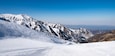 Famous Shymbulak mountain ski resort view with beautiful white and snowy ski lines, blue sky, fresh air. Wonderful picturesque resort for holidays, travelling and sport near Almaty.