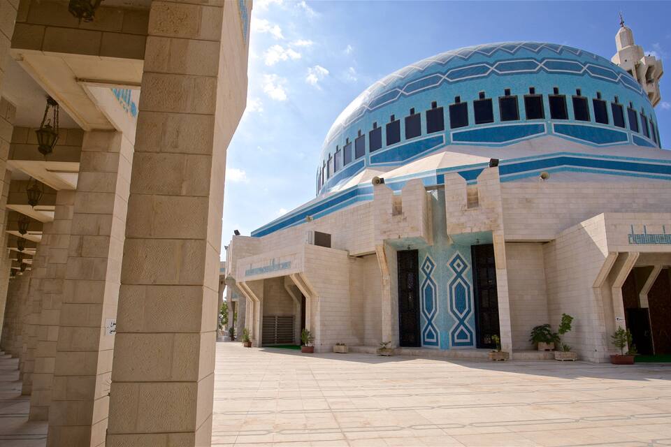 A large mosque with a blue dome and white walls.