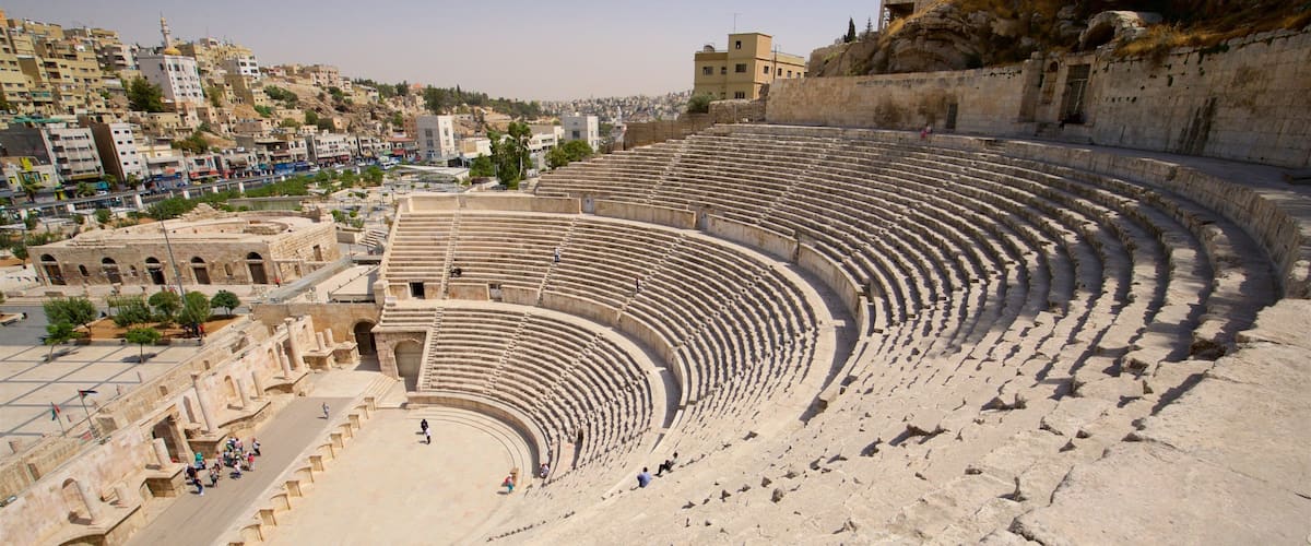 An ancient amphitheater with tiered seating and ruins.