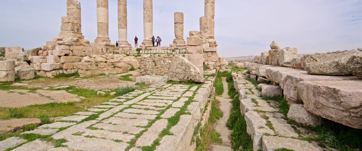 Templo de Hércules que incluye elementos patrimoniales y ruinas de edificios y también un grupo pequeño de personas
