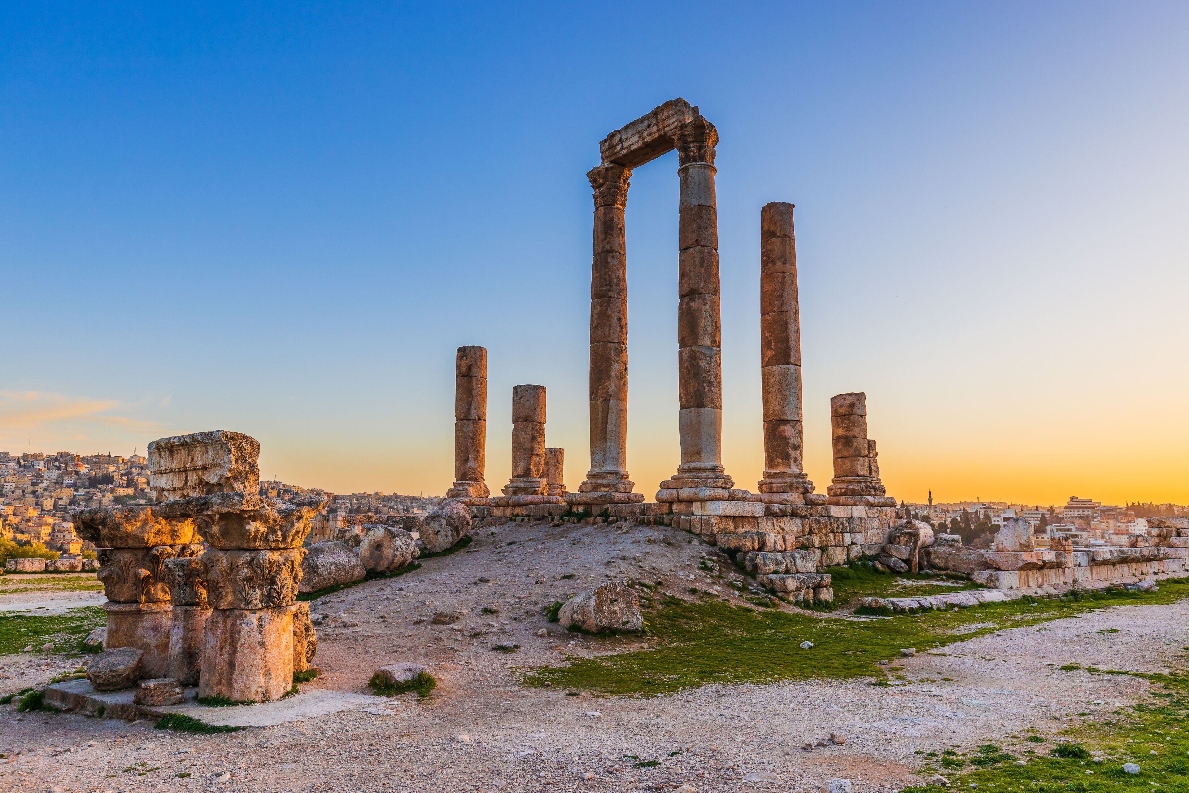 Ancient ruins with columns and stone structures against a clear sky.
