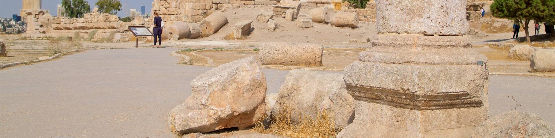Ancient stone ruins with columns and a large stone pillar.