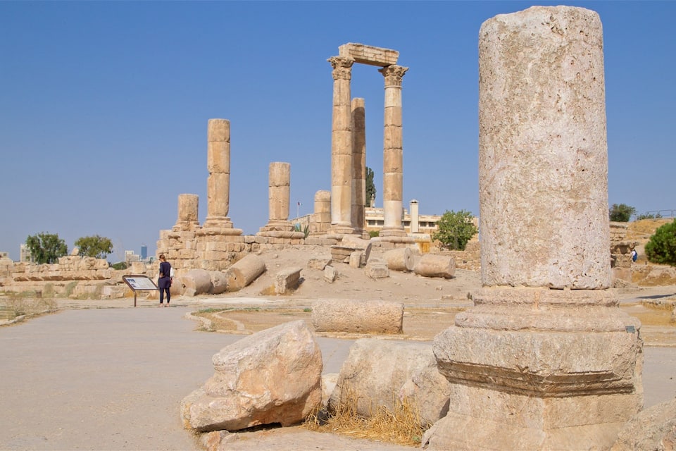 Ancient stone ruins with columns and a large stone pillar.