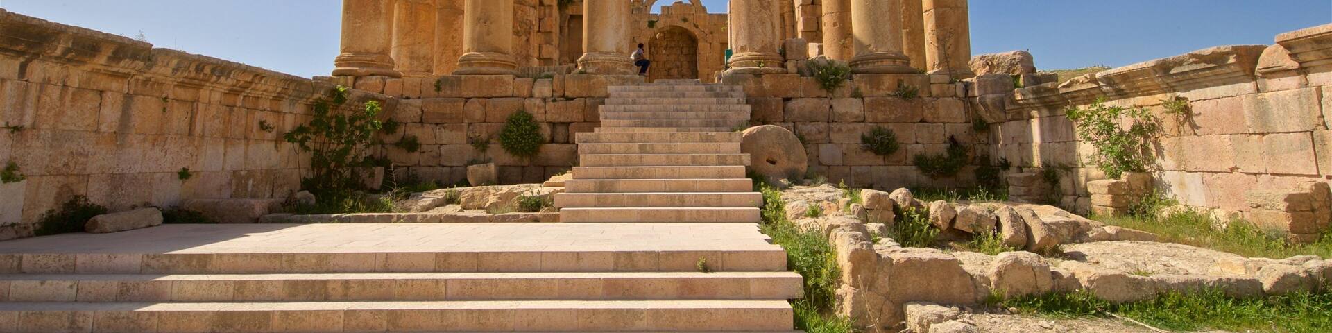 Ancient stone columns and a staircase leading to a historical building.