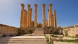 Ancient stone columns and a staircase leading to a historical building.