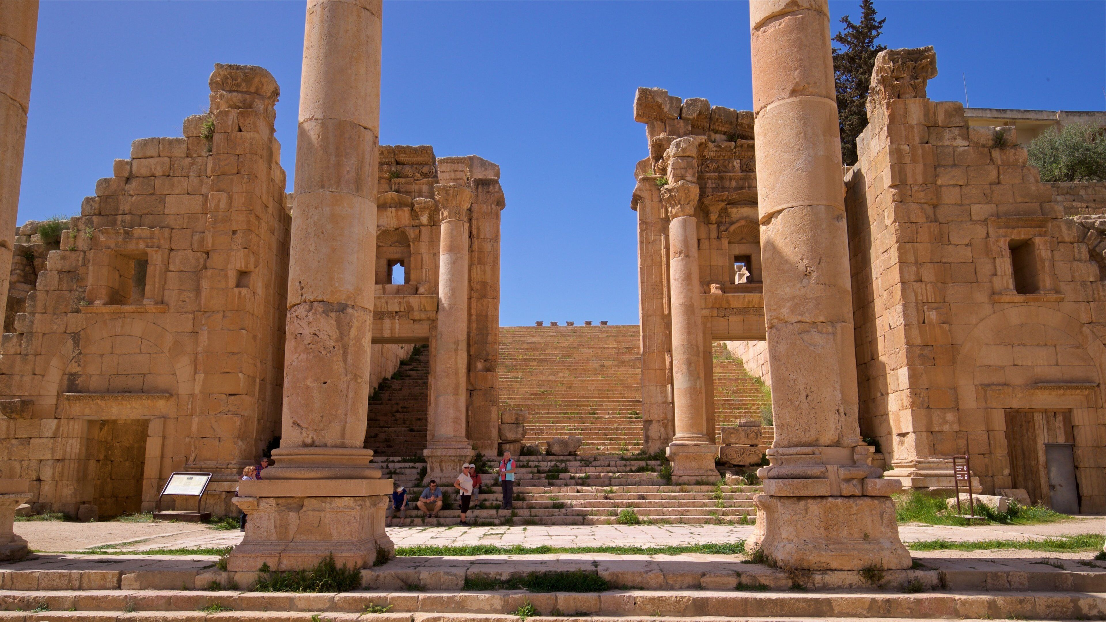 Temple d\'Artémis à Jerash qui includes patrimoine architectural aussi bien que petit groupe de personnes