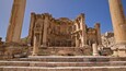 Ancient ruins with large columns and a central structure.