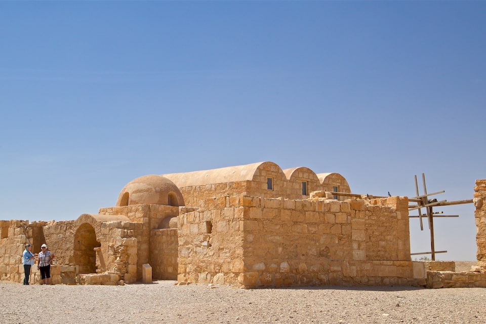An ancient stone structure with arches and a clear blue sky.