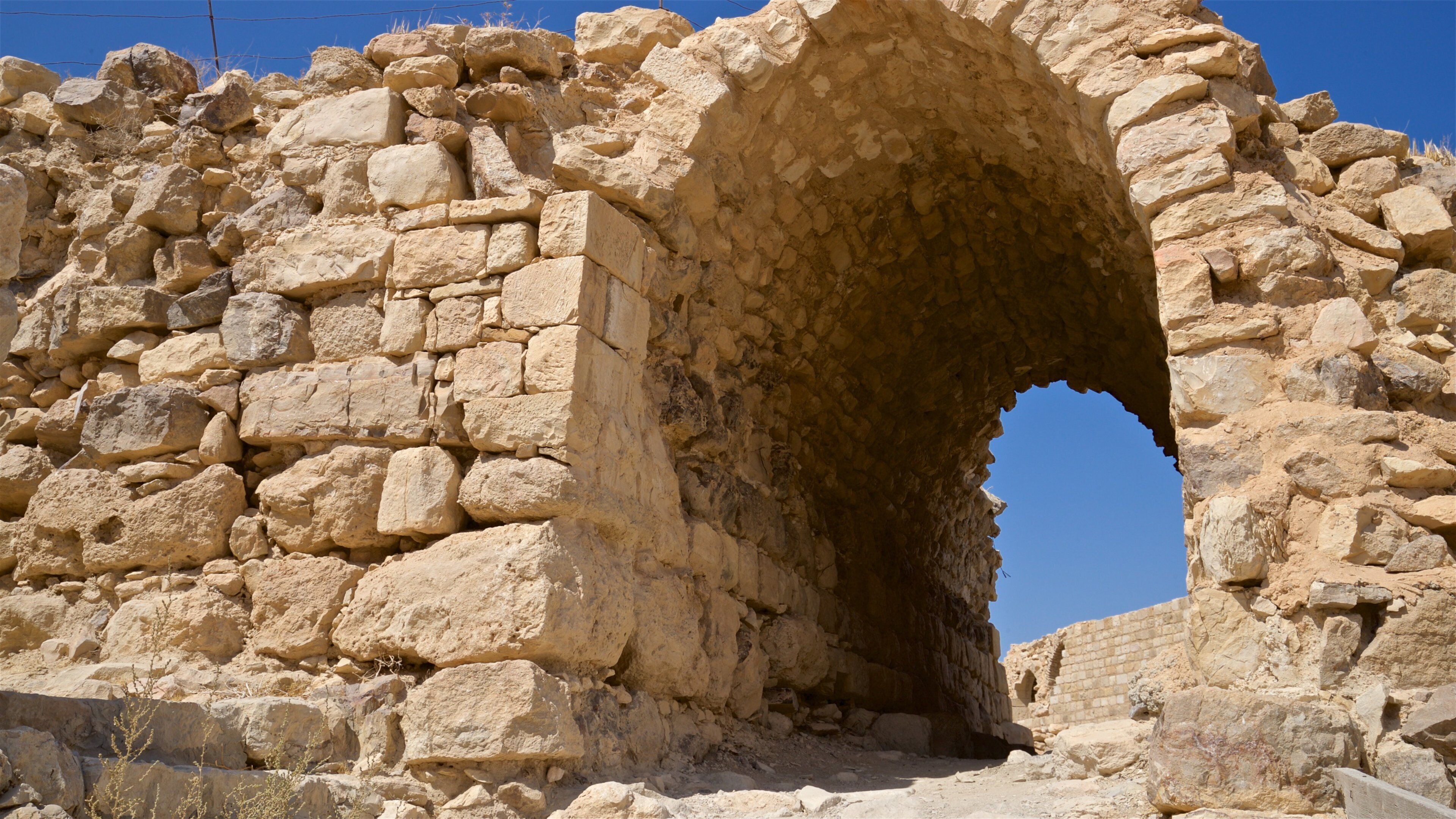 An ancient stone archway with rough, uneven stones.
