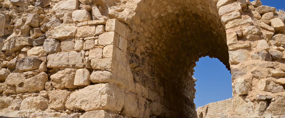 An ancient stone archway with rough, uneven stones.
