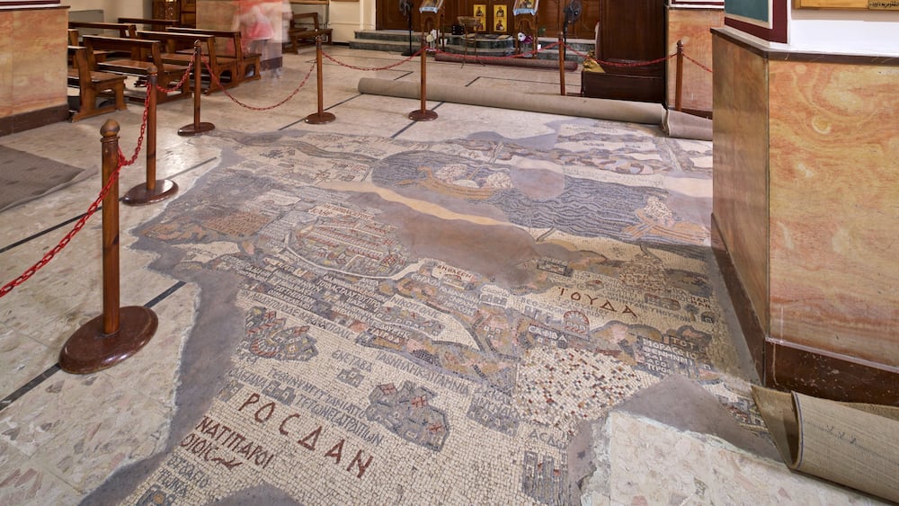A mosaic floor with inscriptions and a wooden structure.